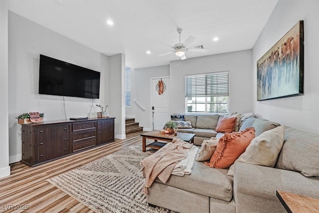 living area with stairway, baseboards, light wood finished floors, recessed lighting, and ceiling fan