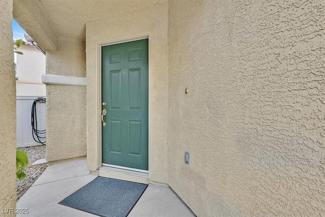 doorway to property featuring stucco siding