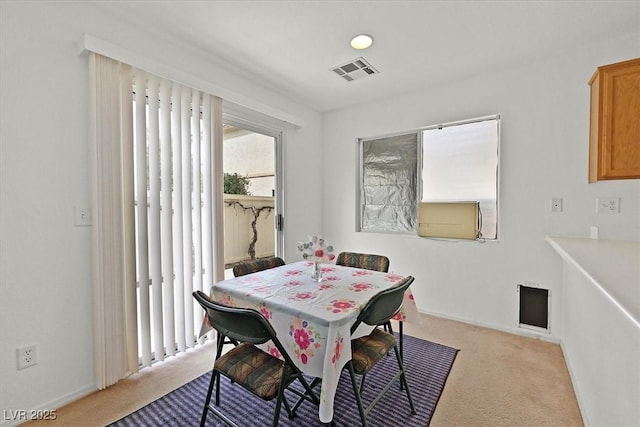 carpeted dining space featuring visible vents and baseboards