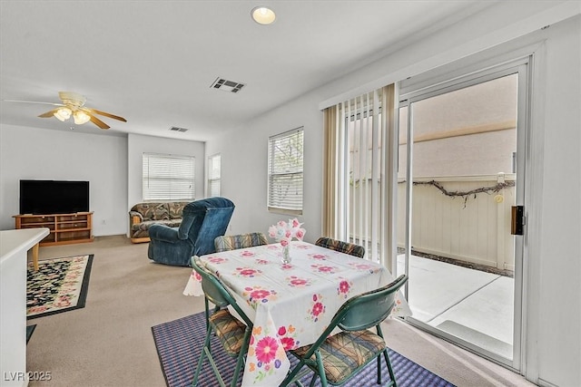 dining space with a ceiling fan, carpet, and visible vents