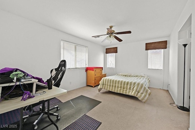 bedroom featuring baseboards, light colored carpet, and ceiling fan