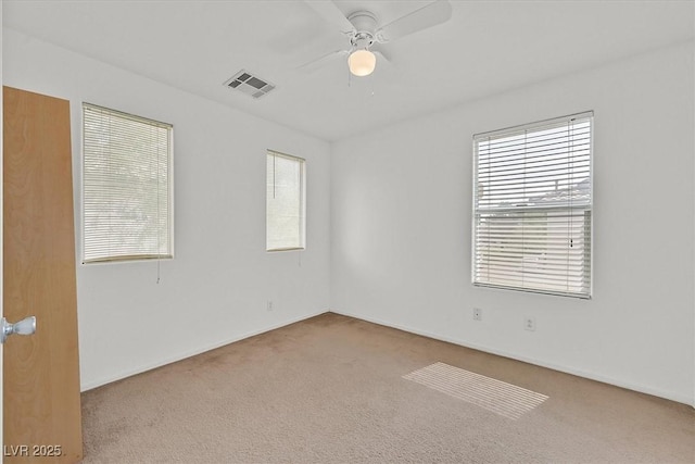 unfurnished room featuring visible vents, carpet floors, and ceiling fan