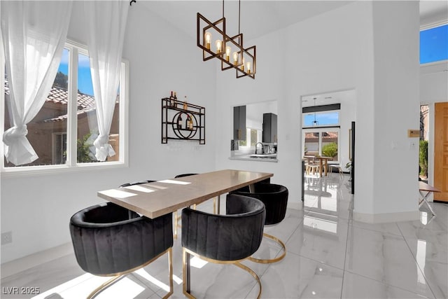 8170 Round Hills Cir, Las Vegas, NV 89113 - dining space featuring plenty of natural light, baseboards, a high ceiling, a chandelier, and light tile patterned floors