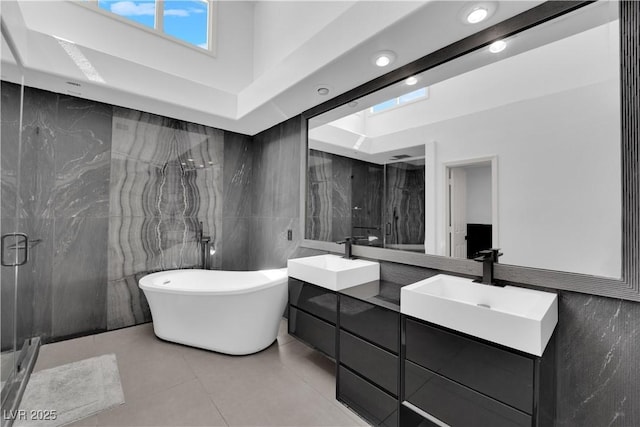 8170 Round Hills Cir, Las Vegas, NV 89113 - bathroom featuring tile walls, double vanity, a freestanding bath, a marble finish shower, and tile patterned flooring