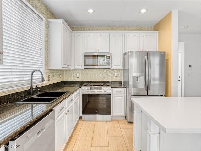 kitchen featuring a sink, backsplash, white cabinetry, recessed lighting, and appliances with stainless steel finishes