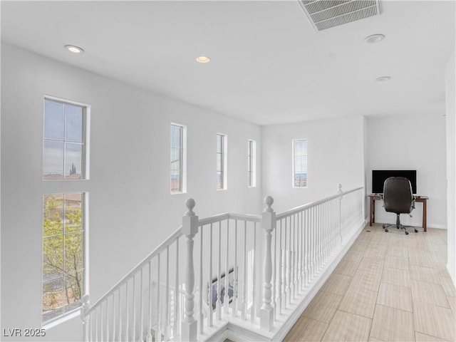 hallway featuring an upstairs landing, visible vents, and recessed lighting