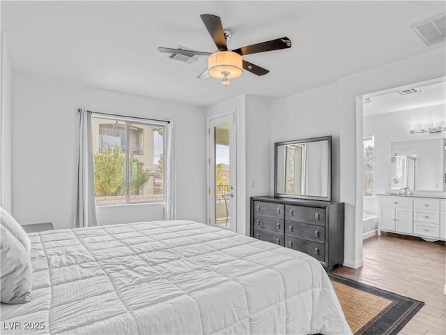 bedroom with visible vents, wood finished floors, access to exterior, and ensuite bathroom