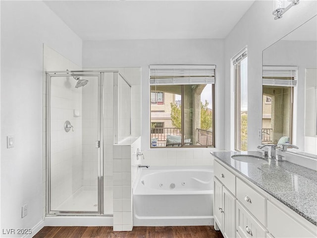 full bathroom featuring vanity, a tub with jets, wood finished floors, and a shower stall