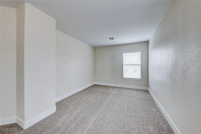 carpeted spare room with visible vents and baseboards