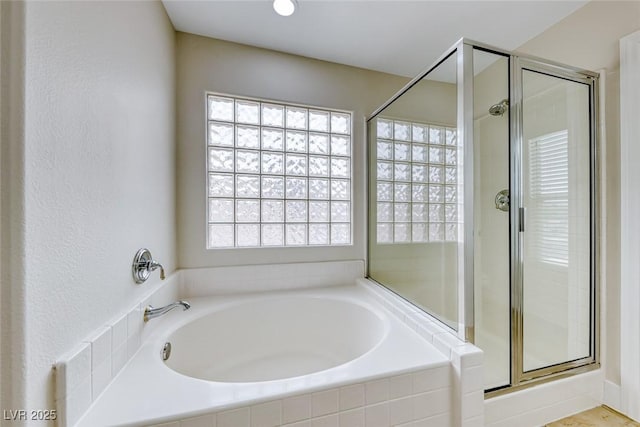 bathroom featuring a shower stall and a garden tub