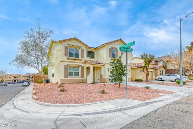 mediterranean / spanish home with a tiled roof, a residential view, driveway, and stucco siding