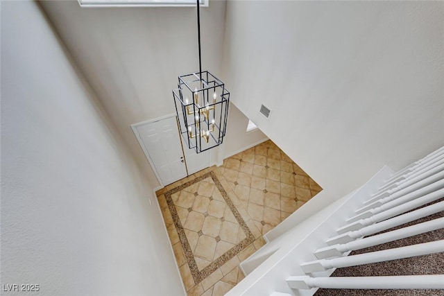 staircase with a notable chandelier and visible vents