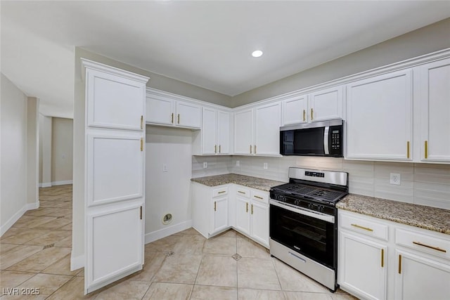 kitchen with decorative backsplash, light tile patterned flooring, light stone countertops, and appliances with stainless steel finishes