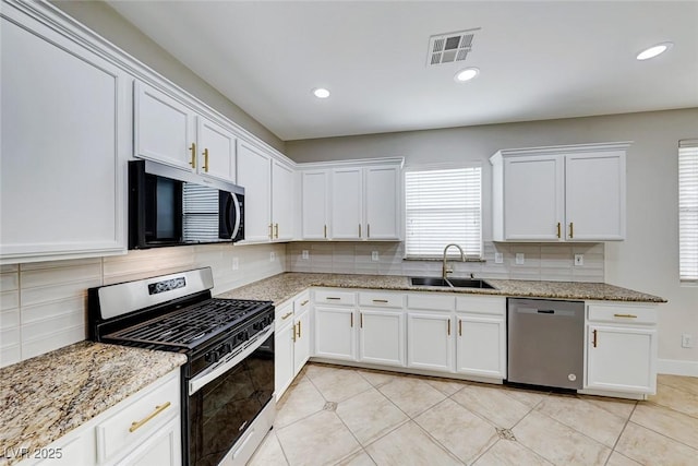 kitchen featuring visible vents, stainless steel appliances, light tile patterned flooring, white cabinetry, and a sink