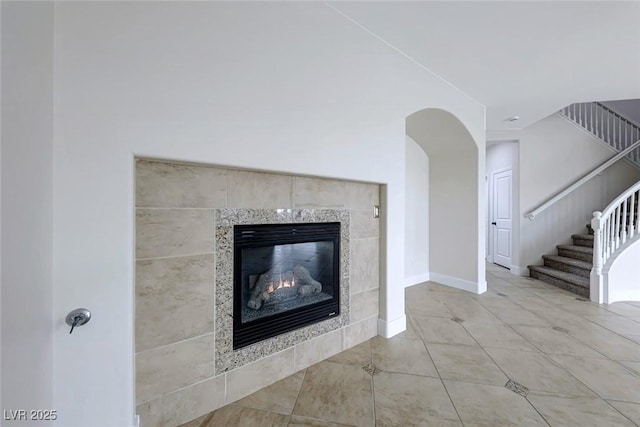 interior details with baseboards and a tiled fireplace