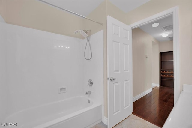 full bath with visible vents, baseboards, bathing tub / shower combination, and tile patterned flooring