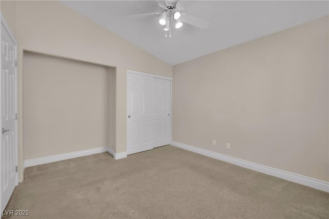 unfurnished bedroom with a closet, carpet floors, baseboards, ceiling fan, and vaulted ceiling