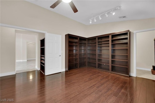 unfurnished room featuring a ceiling fan, wood finished floors, visible vents, and baseboards