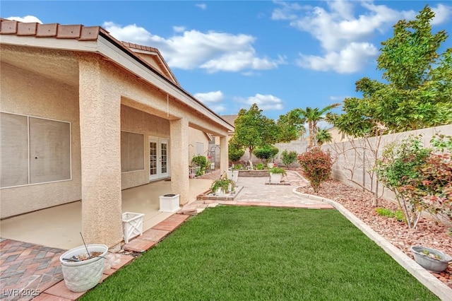 view of yard with a fenced backyard, french doors, and a patio