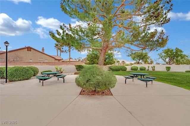 view of home's community with a yard, a patio, and fence