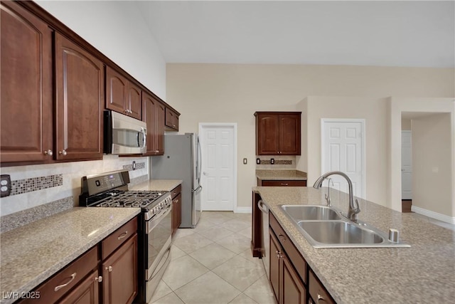 kitchen featuring light tile patterned floors, a sink, stainless steel appliances, light countertops, and backsplash