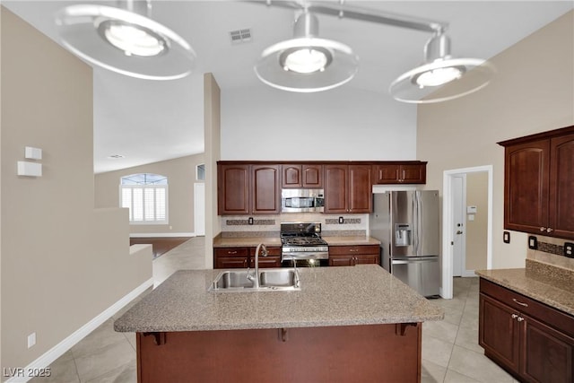 kitchen featuring visible vents, appliances with stainless steel finishes, a breakfast bar area, and a sink