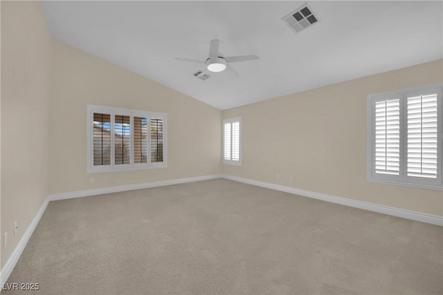 spare room featuring visible vents, lofted ceiling, baseboards, and a ceiling fan