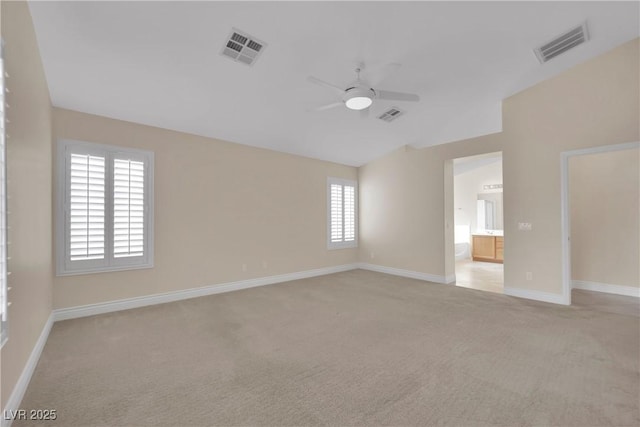 empty room featuring light colored carpet, a ceiling fan, and visible vents