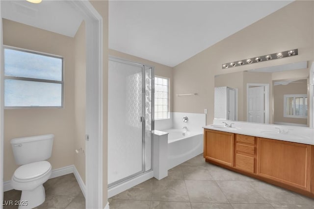 bathroom featuring a shower stall, a garden tub, double vanity, vaulted ceiling, and a sink