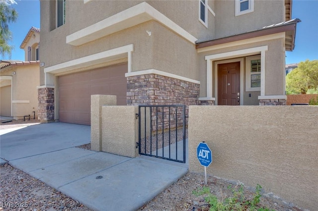 entrance to property featuring stone siding, stucco siding, and a garage