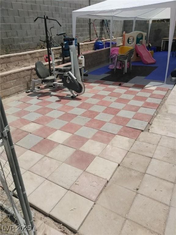 view of patio / terrace featuring a playground and fence