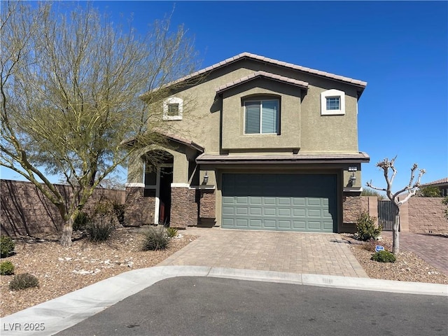 view of front facade featuring a garage, driveway, stucco siding, and fence