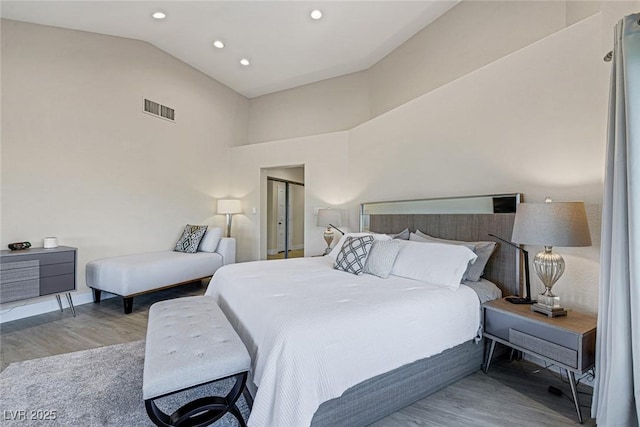 bedroom with recessed lighting, wood finished floors, visible vents, and high vaulted ceiling