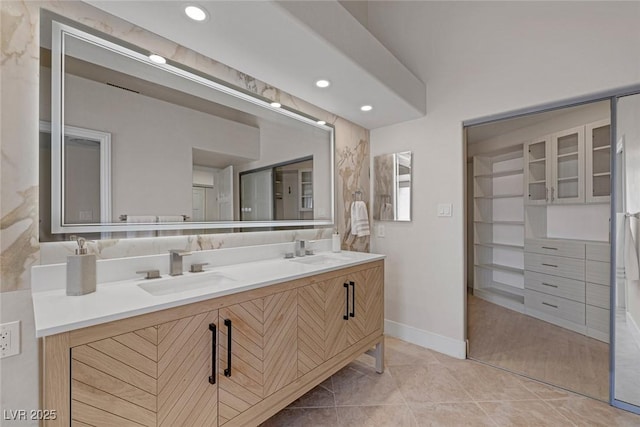 bathroom featuring a sink, double vanity, recessed lighting, and tile patterned floors