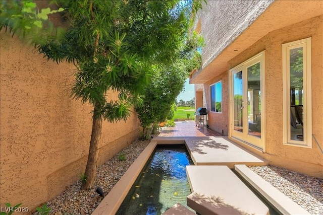 exterior space featuring grilling area and an outdoor pool