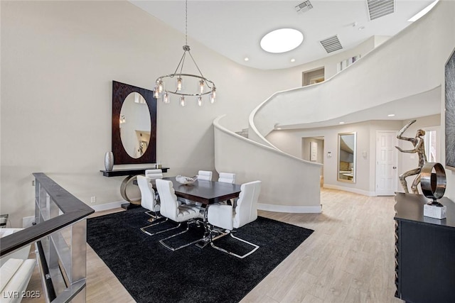 dining area with visible vents, baseboards, and wood finished floors