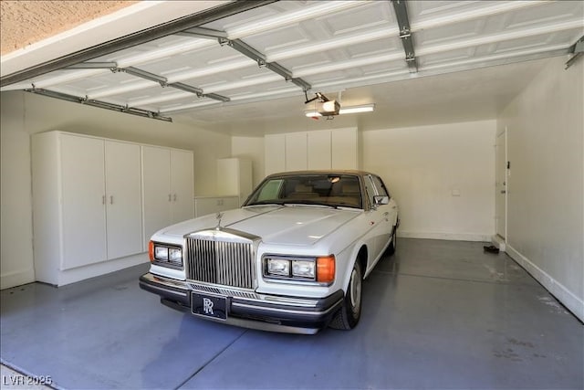 garage featuring a garage door opener and baseboards