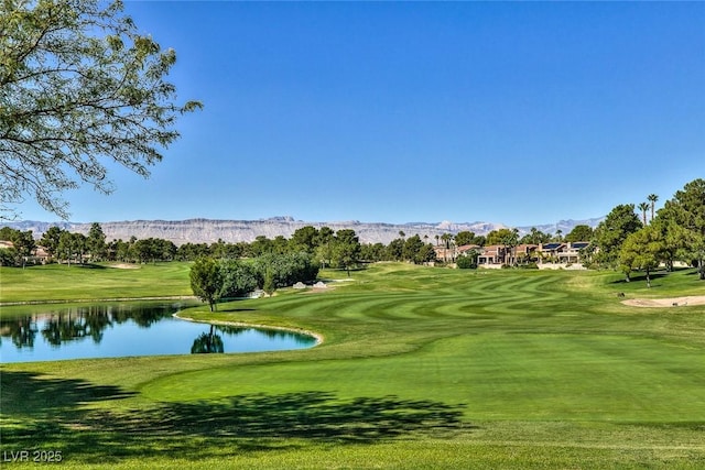 surrounding community with view of golf course, a yard, and a water and mountain view