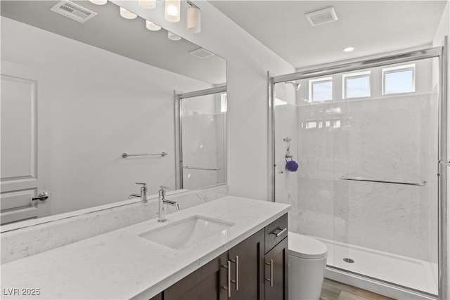 full bathroom featuring visible vents, a shower stall, and vanity