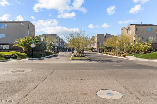 view of road with curbs, a residential view, traffic signs, and sidewalks