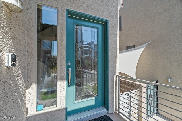 doorway to property featuring stucco siding