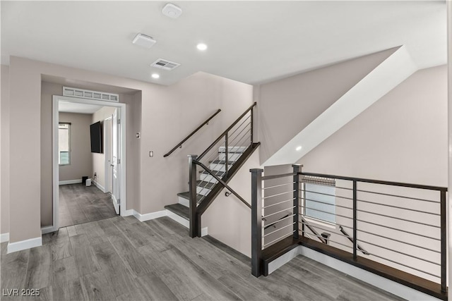 stairs with visible vents, recessed lighting, baseboards, and wood finished floors