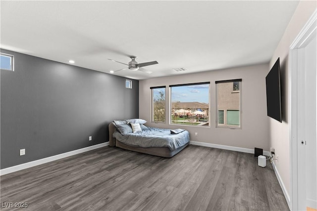 bedroom with visible vents, baseboards, and wood finished floors