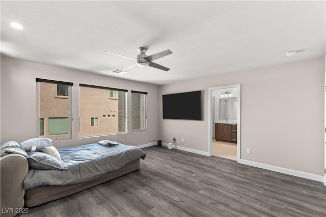 bedroom featuring visible vents, baseboards, dark wood finished floors, ensuite bath, and a ceiling fan