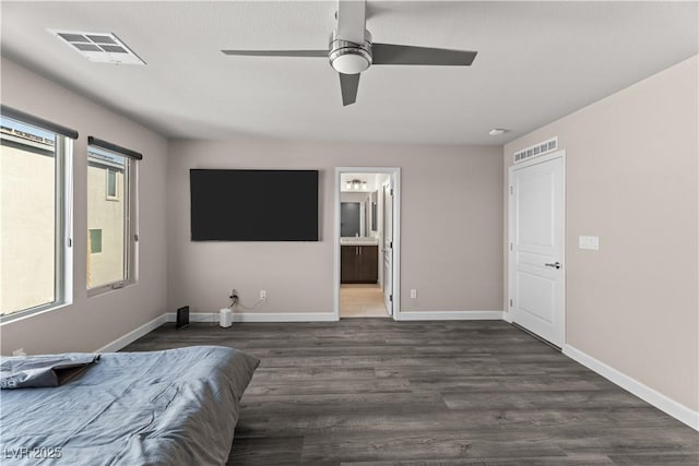 bedroom featuring multiple windows, wood finished floors, visible vents, and baseboards