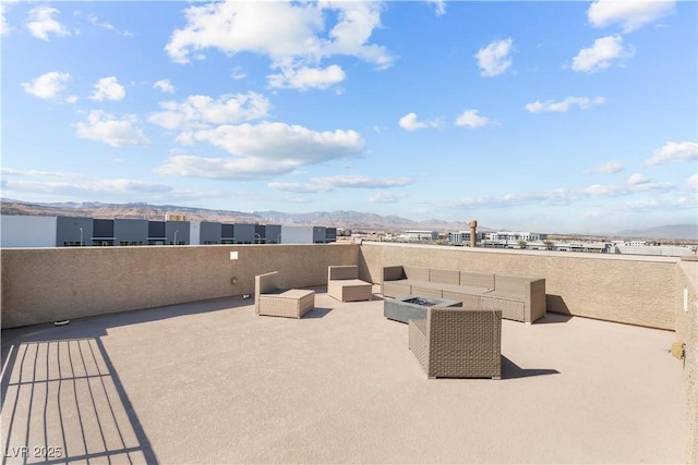 view of patio with a mountain view and an outdoor living space with a fire pit