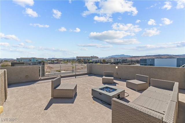 view of patio / terrace featuring a mountain view and an outdoor living space with a fire pit