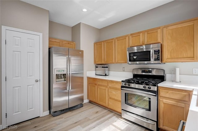 kitchen featuring stainless steel appliances, light wood-style flooring, light brown cabinetry, and light countertops