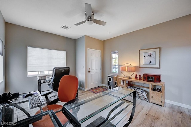 office with light wood finished floors, baseboards, a ceiling fan, and a wealth of natural light