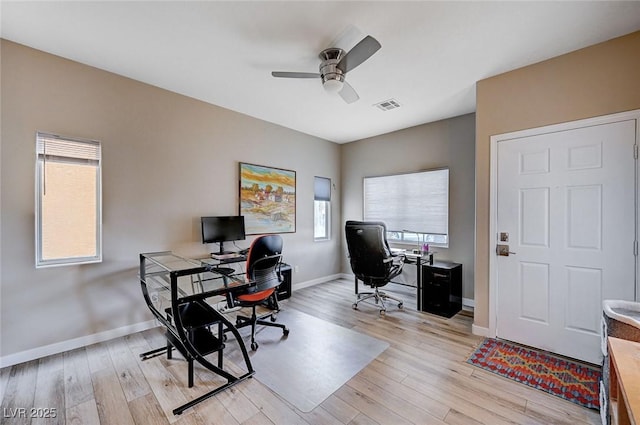 home office with baseboards, light wood-style floors, visible vents, and ceiling fan